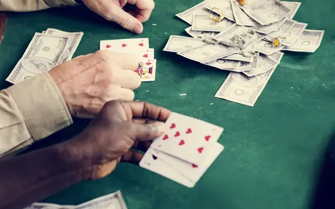 Players at a poker table with cash and jewellery, illustrating real money in PPPoker